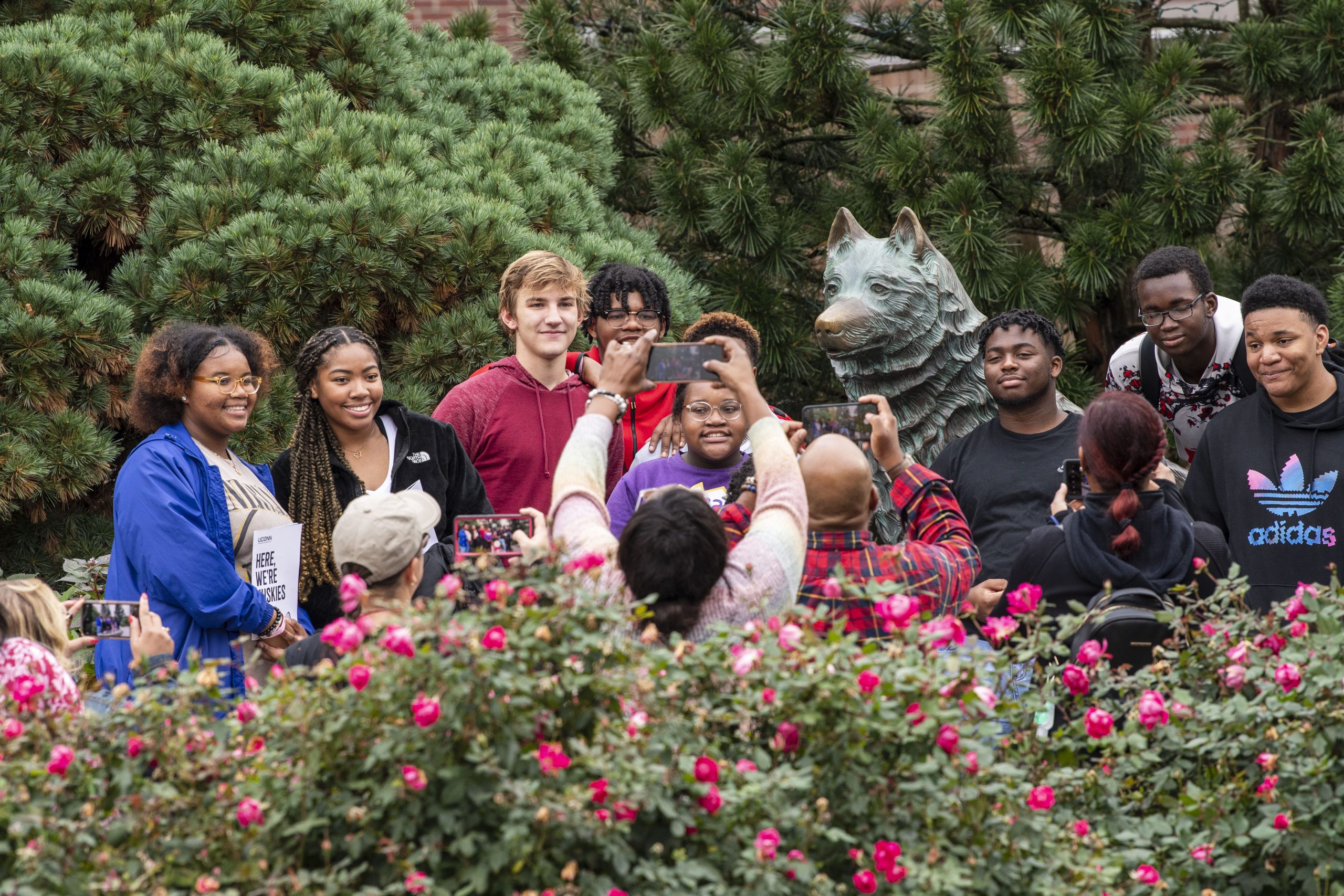 Students gathered around the husky dog statue.